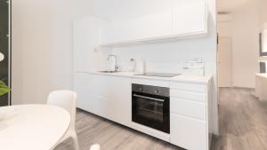 米兰Italianway - Merlo 3的白色的厨房设有水槽和炉灶。