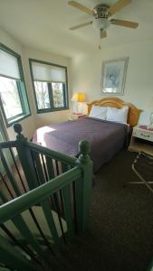 斯特金贝Snug Harbor Inn的一间卧室配有一张带风扇和窗户的床。