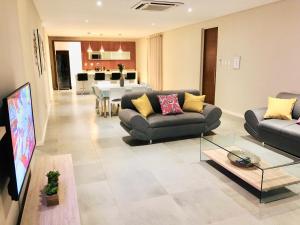 埃祖尔韦尼The Executive - Exclusive Self-Catering Apartments - Ezulwini的带沙发的客厅和用餐室