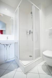 朗吉斯普瑞米尔奥利伦吉经典酒店的带淋浴和盥洗盆的白色浴室