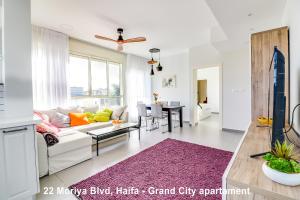 海法Carmel Boutique Apartments的客厅配有白色沙发和紫色地毯