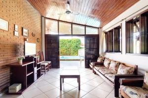 乌巴图巴BEST HOUSES 4: CASA COM PISCINA NA PRAIA GRANDE的客厅配有沙发和桌子