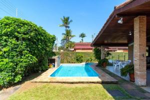 乌巴图巴BEST HOUSES 4: CASA COM PISCINA NA PRAIA GRANDE的一座房子后院的游泳池