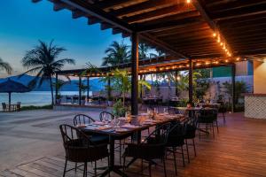 锡瓦塔塔内霍Thompson Zihuatanejo, A Beach Resort, by Hyatt的一个带桌椅的用餐区和海滩