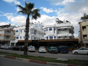 安塔利亚萨瓦酒店的白色建筑前的棕榈树