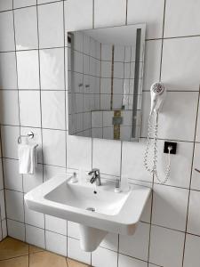 杜伊斯堡Hotel Akazienhof的白色的浴室设有水槽和镜子