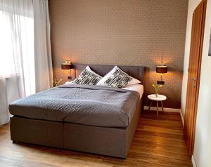 杜伊斯堡Hotel Akazienhof的一间卧室配有一张带两个枕头的床