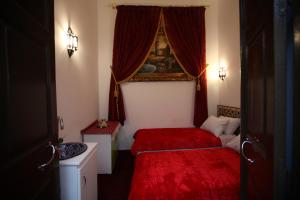 丹吉尔Dar Essaki 1886的一间卧室设有两张带红色床单的床和窗户。