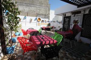 丹吉尔Dar Essaki 1886的庭院配有红色和绿色的桌椅