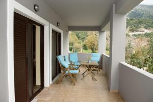 StróponesHouse Evia的阳台设有带蓝色椅子和桌子的庭院。