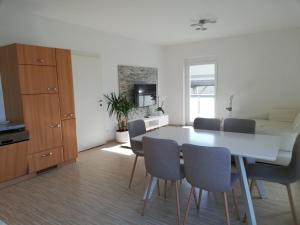 格拉特科恩Gemütliches 3 Zimmer Apartment nahe Graz的厨房以及带白色桌椅的用餐室。