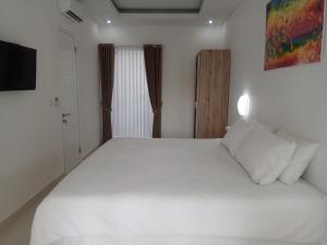 沙努尔The Bali Bubble的卧室配有一张白色大床和电视。