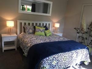 奥玛鲁Highlands on Homestead的一间卧室配有一张带枕头的床和两盏灯。