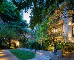 曼谷Ariyasom Villa - SHA Extra Plus的一座花园,位于一座建筑的中间