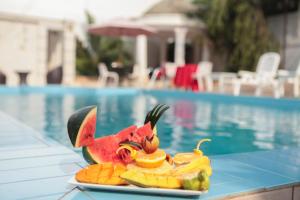 布琼布拉Hotel Kangaroo Bujumbura的池边桌子上的一盘水果