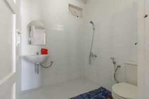 巴东RedDoorz Syariah near Universitas Negeri Padang的白色的浴室设有卫生间和水槽。