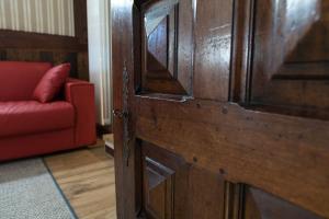 因特罗德Maison Lo Triolet的客厅的木门,配有红色沙发