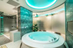高雄乐芙优旅精品旅馆的带浴缸和玻璃淋浴间的浴室。