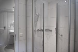 福森阿拉特湖餐厅酒店的浴室里设有玻璃门淋浴