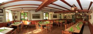 施泰因加登嘎斯托夫格拉夫酒店的餐厅设有木桌、椅子和绿色餐巾