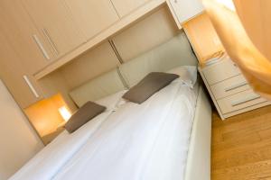 卡里索洛罗塔拉罗萨德拉多洛米蒂酒店的一间卧室配有带白色床单和枕头的床。