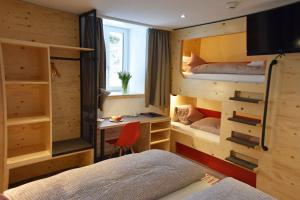 米伦艾格宾客酒店的一间卧室配有两张双层床和一张书桌