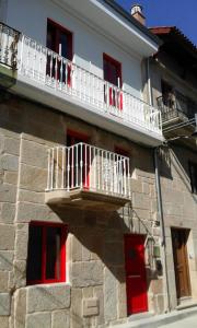 坎加斯德穆拉索Casa Choupas的阳台位于大楼的一侧,设有红色窗户