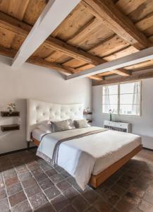 布拉格设计聂鲁达酒店的一间卧室设有一张大床和木制天花板。