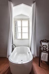 布拉格设计聂鲁达酒店的带窗户的浴室内的白色浴缸