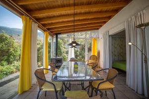 洛斯·亚诺斯·德·阿里丹Casa Ruth的阳台的用餐室配有玻璃桌和椅子