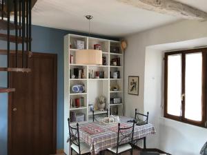奥尔塔圣朱利奥Appartamento Orta centro的一间带桌子和书架的用餐室
