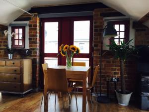 格洛斯特Victorian Penthouse Apartment的用餐室,配有一张桌子和花瓶