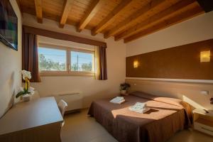 巴多利诺Agriturismo Tre Colline的酒店客房设有两张床和窗户。