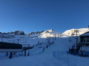 帕斯底拉卡萨米尔迪尔酒店的雪覆盖的滑雪场,设有滑雪缆车