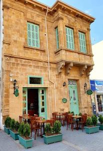 北尼科西亚Hotel Valide Hanim Konak的大楼前设有桌椅的餐厅