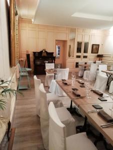 谢尔河畔塞勒Le Lion d'Or的一间带桌子和白色椅子的用餐室
