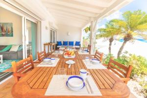 圣马丁岛VILLA SAPHIR的一间带木桌和椅子的用餐室
