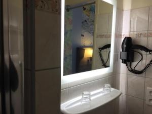 塔布林荫道酒店的浴室设有水槽和镜子,配有电话