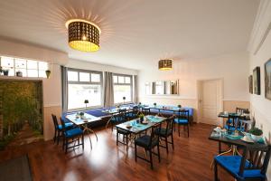 不来梅港Hotel Wurster Kroog的一间配备有桌子和蓝色椅子的用餐室