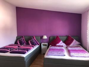 鲁斯特Apartment Country Europa-Park Ticket Garantie的紫色墙壁客房的两张床