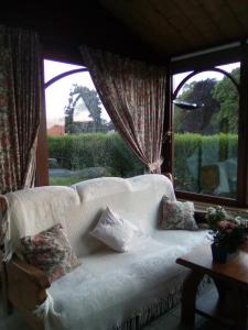 萨乌丁Le Clos Fleuri的客厅设有白色沙发,配有窗户