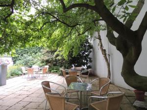 杜塞尔多夫杜塞尔多夫&塔古格CVJM酒店的树下带桌椅的庭院