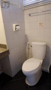 曼谷娜娜城市酒店的一间带白色卫生间的浴室和一部电话