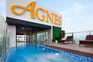 芽庄Agnes Nha Trang Hotel的大楼前设有游泳池的酒店