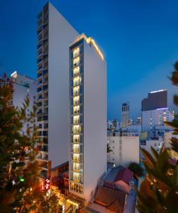芽庄Agnes Nha Trang Hotel的一座高大的白色建筑,上面有灯