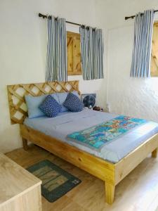 贝圣安那可可湾别墅酒店的一间卧室配有一张带蓝色枕头的木床。