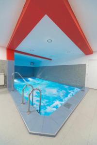 波德戈里察Hotel Piramida的红色天花板的房间内的游泳池