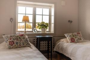 恩雪平Rekasta Bed & Breakfast的一间卧室设有两张床和窗户。