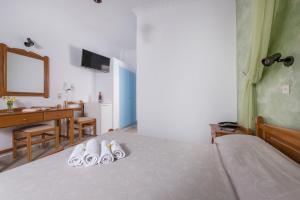 卡特瑞杜斯奥林匹亚酒店 的一间卧室配有一张床和2双拖鞋
