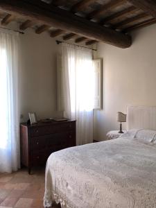 拉文纳Le Case Di San Vitale Easy的一间卧室配有一张床、一个梳妆台和一扇窗户。